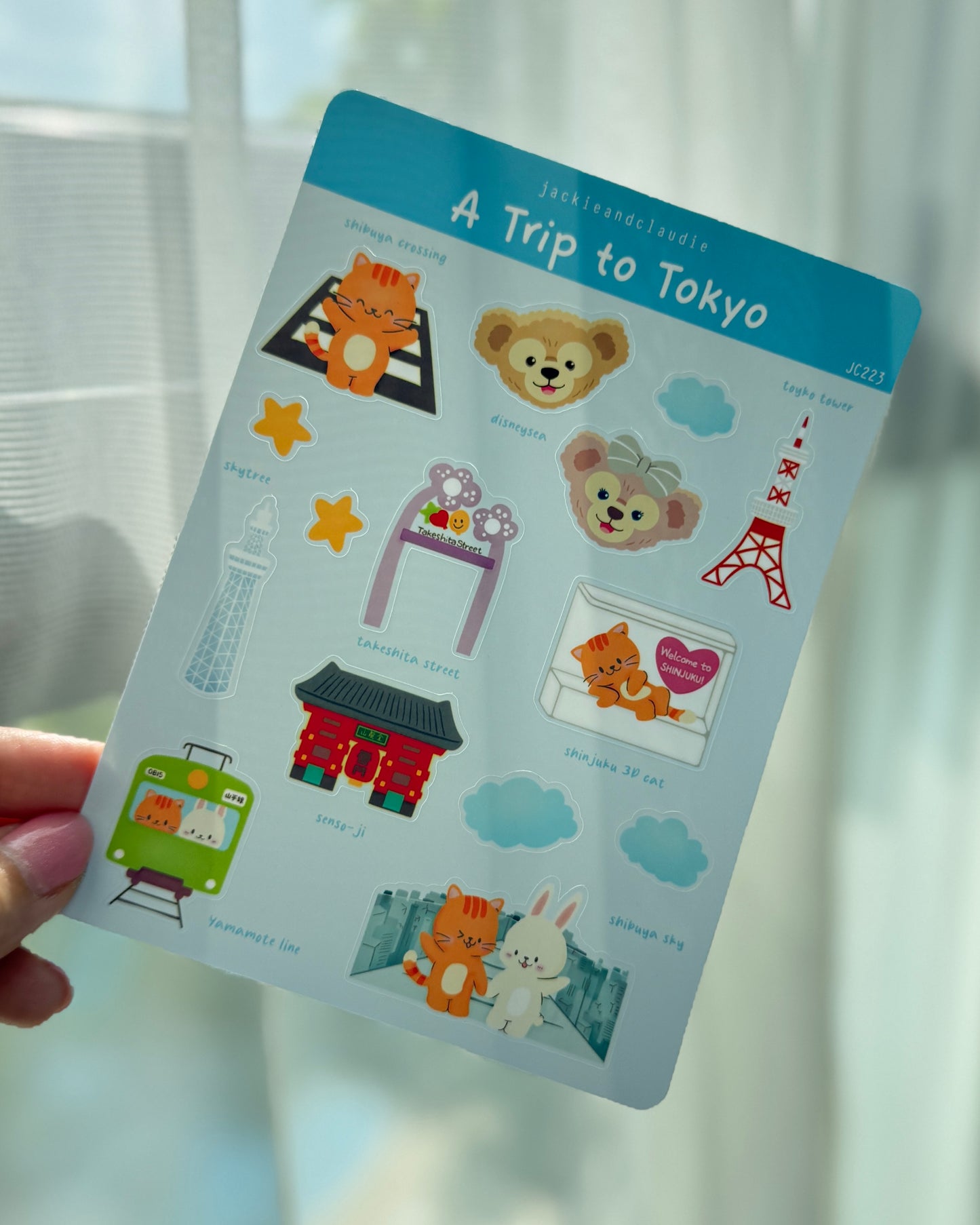 Sheet of stickers titled 'A Trip to Tokyo' held by a hand with a blurred background.