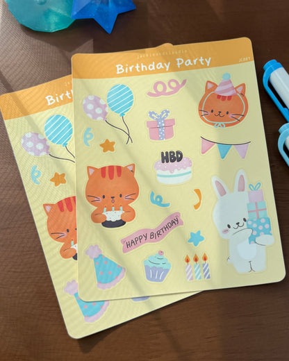 Two birthday-themed stickers with cartoon animals and text on a wooden surface.