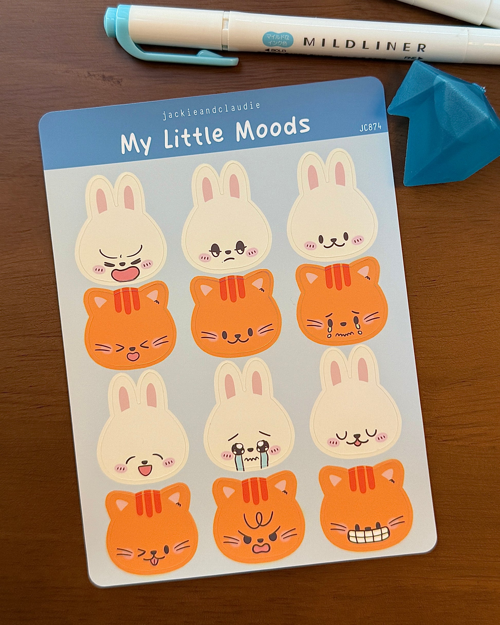 Sheet of 'My Little Moods' stickers with cartoon animals on a wooden surface.